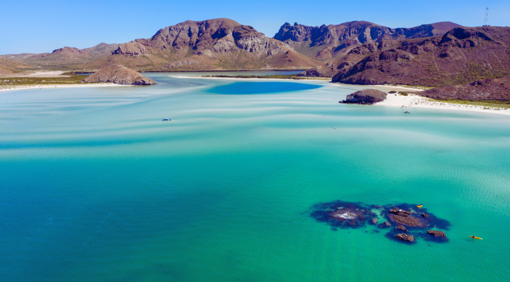Aerial view of Playa Balandra in La Paz, Baja California Sur, Mexico, with its crystal-clear turquoise waters and surrounding mountains.