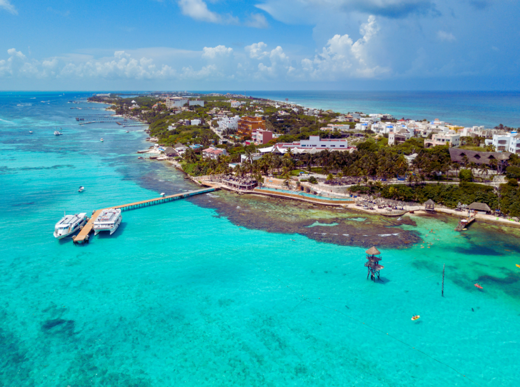 Aerial view of Isla Mujeres in Mexico, featuring its turquoise waters, sandy beaches, and coastal village.