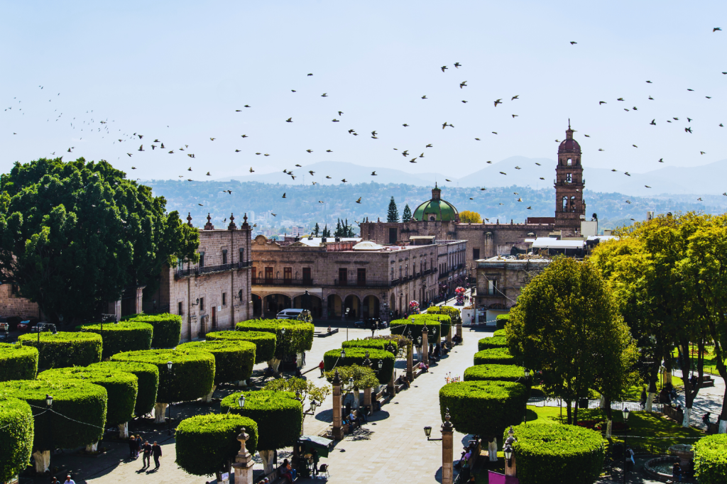 Aerial view of Morelia's historic center in Michoacan, Mexico, featuring the Catedral de Morelia and a lush green plaza.